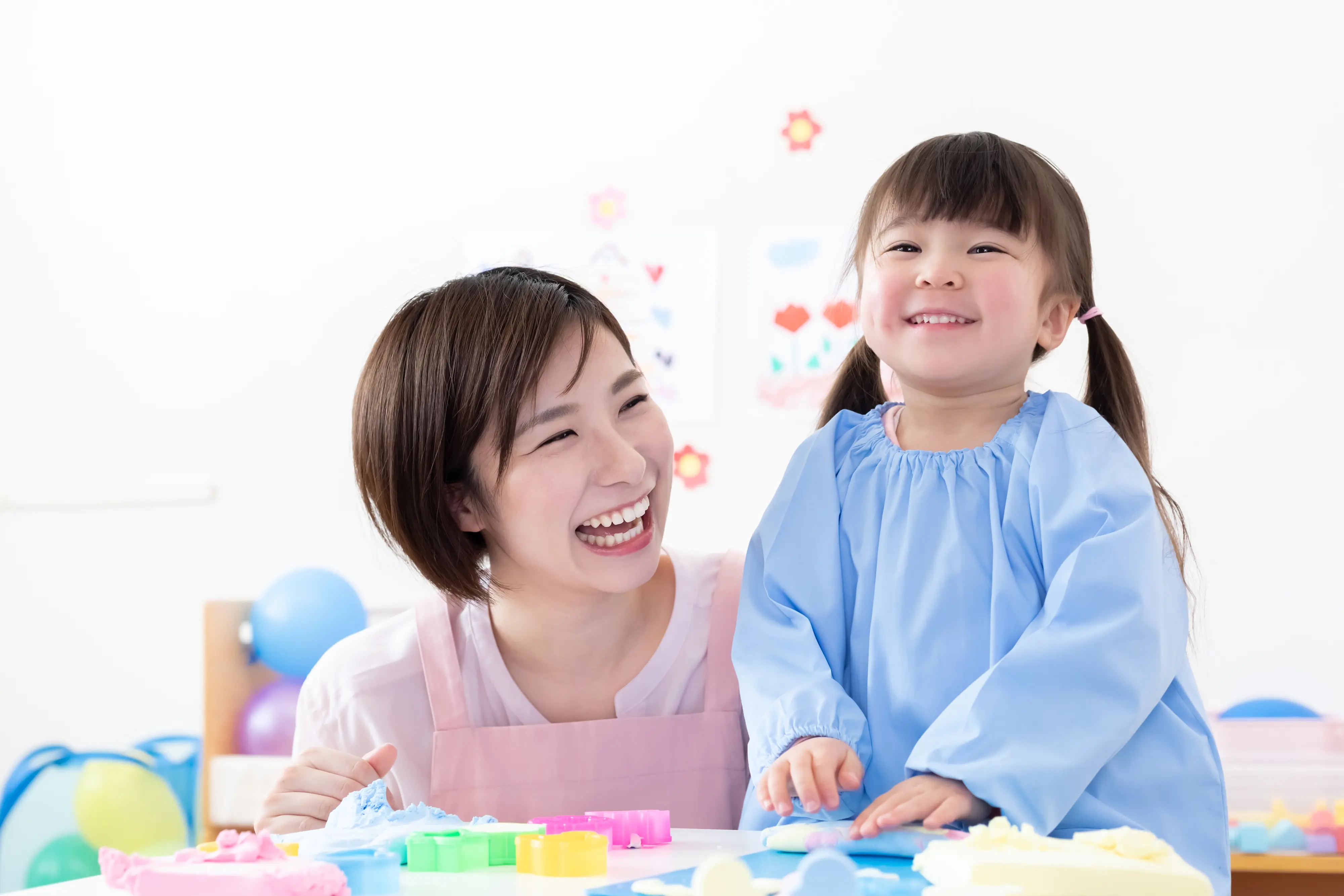 微笑む保育士の女性とこども